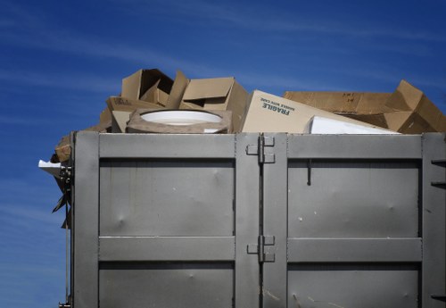 Depot operator lifting a commercial bin with PPE